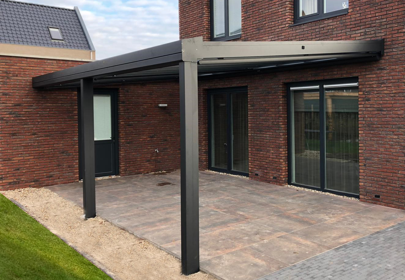 Zwarte terrasoverkapping met glazen lessenaars dak aan gevel van huis. Terrasoverkapping ook mogelijk als carport aan de woning