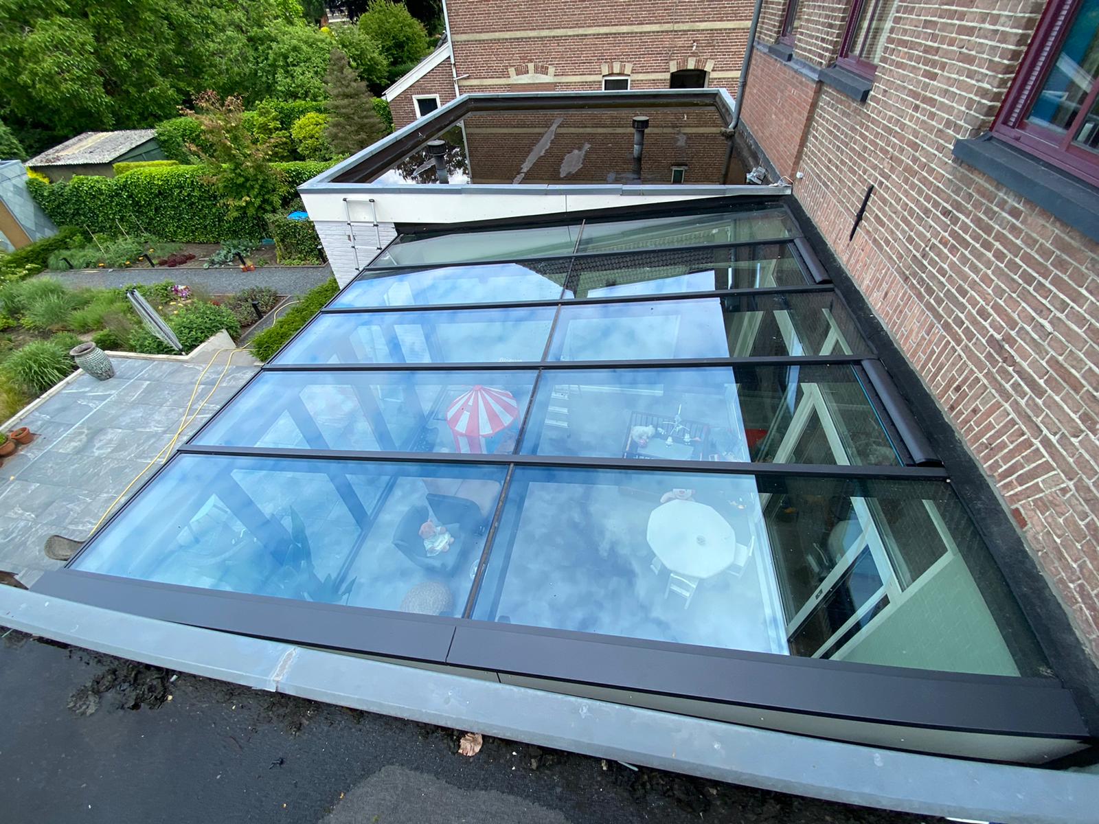 Grijze serre met lessenaar dak en vouwwand na het vervangen van het glas