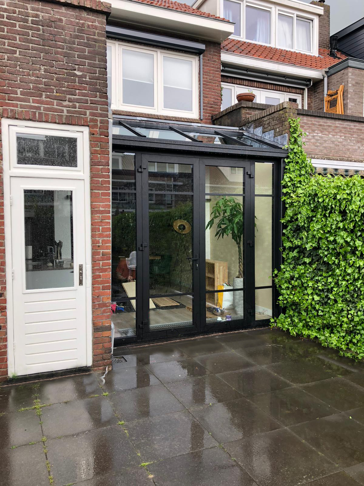 Een kleine serre met glazen lessenaarsdak