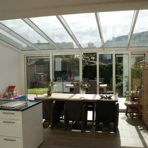 Binnen aanzicht witte serre met 4-delige schuifpui met lessenaarsdak.