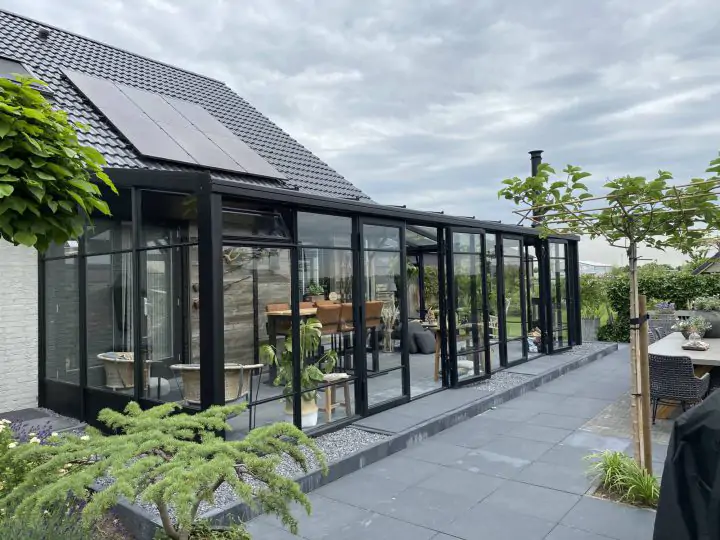 Zwarte tuinkamer serre met stolpdeuren en roedeverdeling