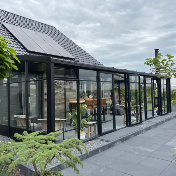 Zwarte tuinkamer serre met stolpdeuren en roedeverdeling