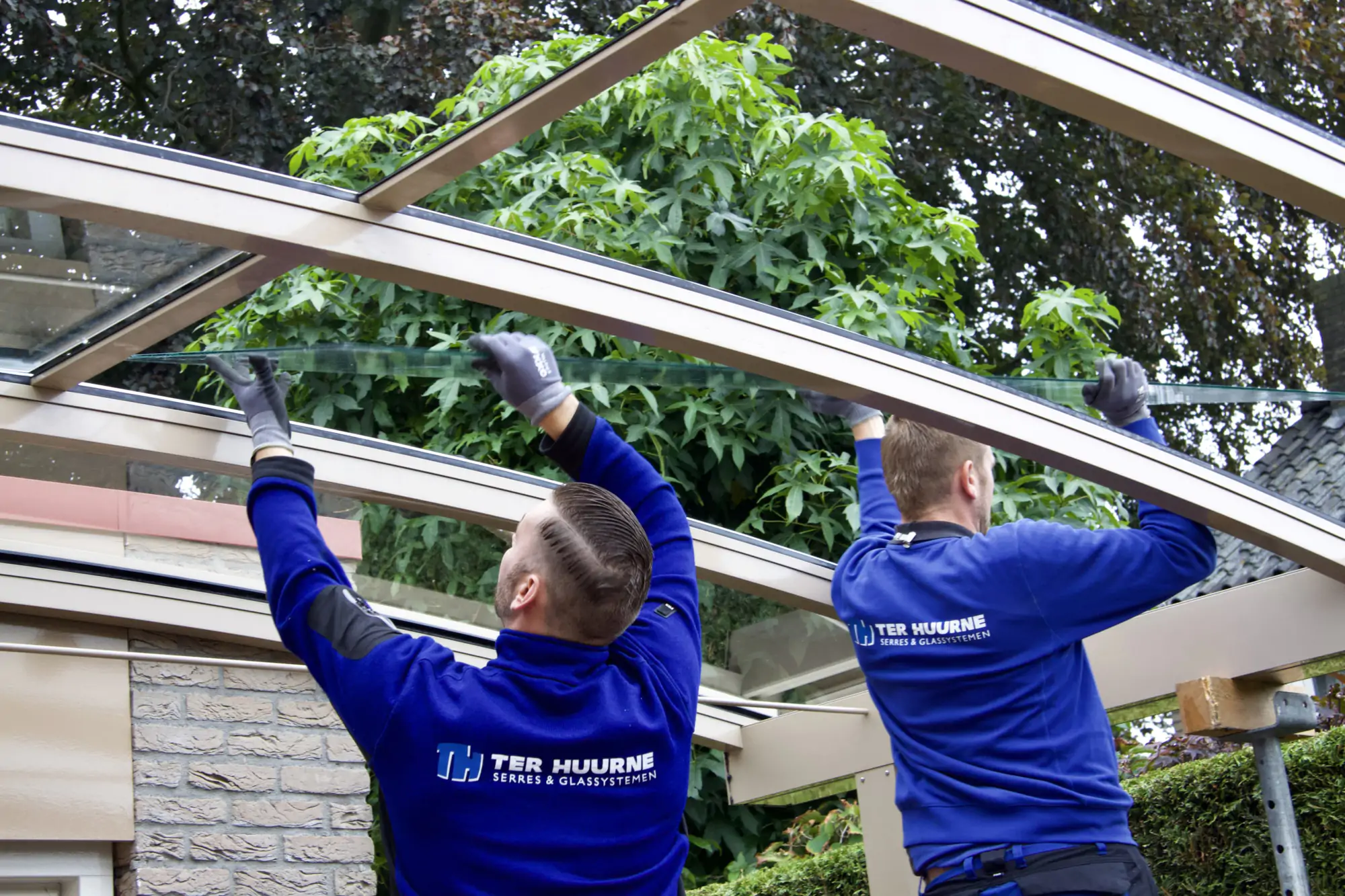 Monteurs van Ter Huurne plaatsen glas in de aluminium constructie van een maatwerklichtstraat.