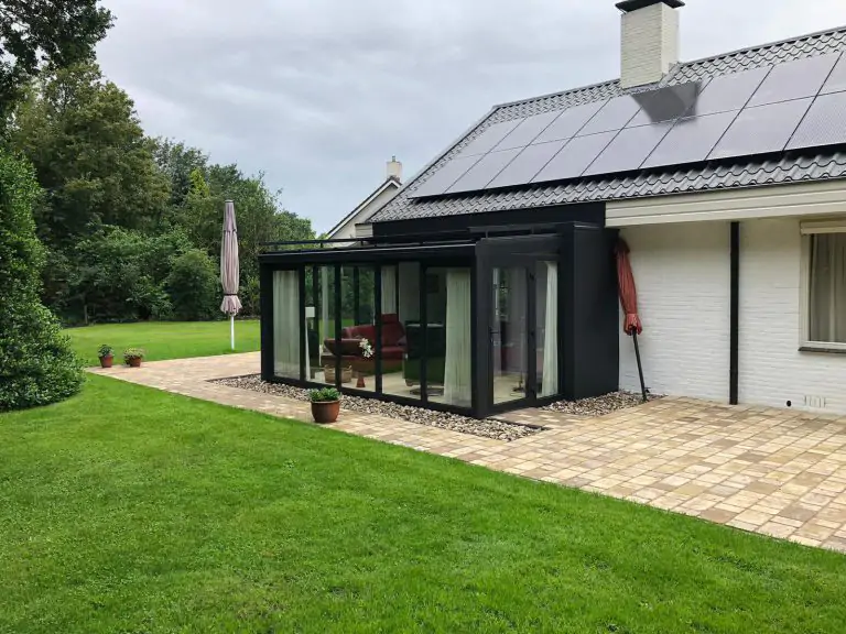 Zwarte serre zijaansluiting aan wit huis met geen condens binnenkant raam