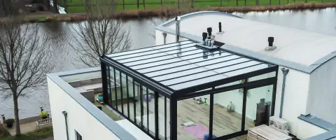 Een huis met een glazen dak en een rivier, met een serre balkon.