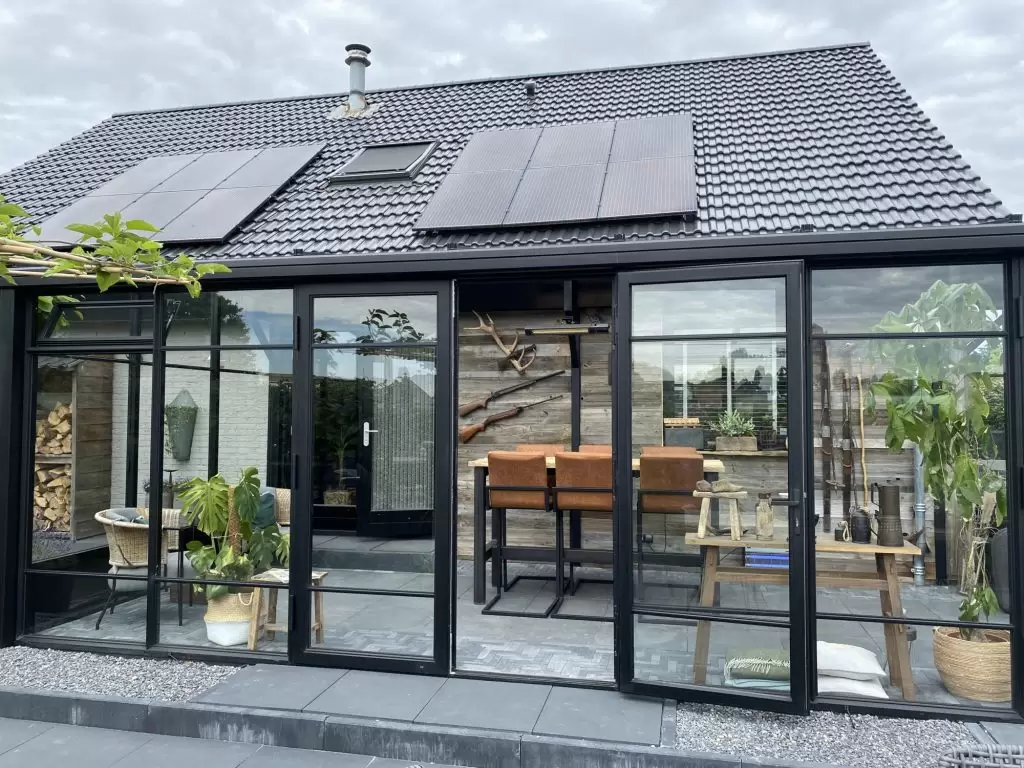 Zwarte serre/tuinkamer met plat dak en openslaande deuren
