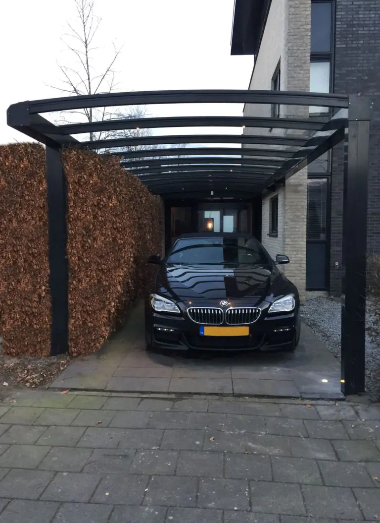 Donkergrijze Ter Huurne carport, aangebouwd aan het huis met een gebogen dak.