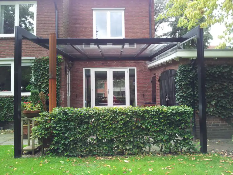 Zwarte terrasoverkapping aluminium maatwerk met glazen dak in de achtertuin